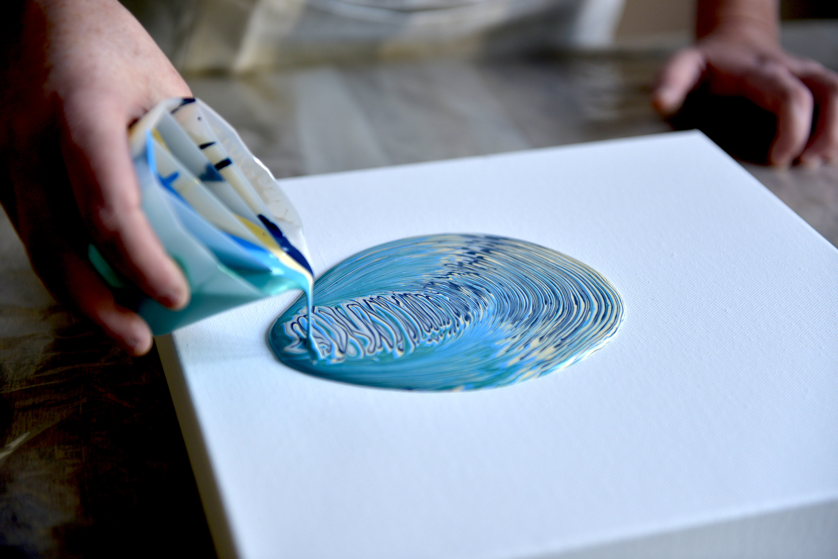 Colourful acrylic paint pouring process on canvas